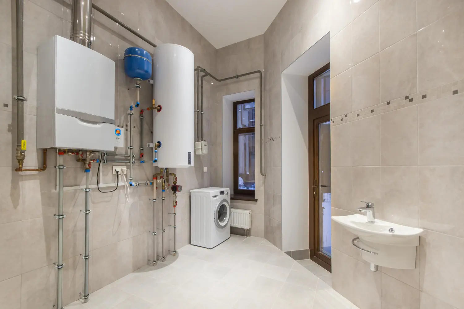 Heizungsraum mit Heizungsanlage. Wandhängende Gastherme und elektrischer Warmwasserbereiter 